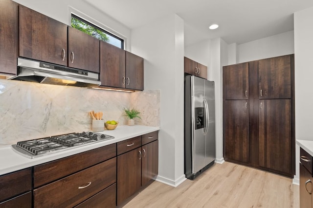 1500 Summit St Unit 4, Austin, TX 78741 - kitchen featuring stainless steel appliances, under cabinet range hood, light wood-type flooring, and light countertops