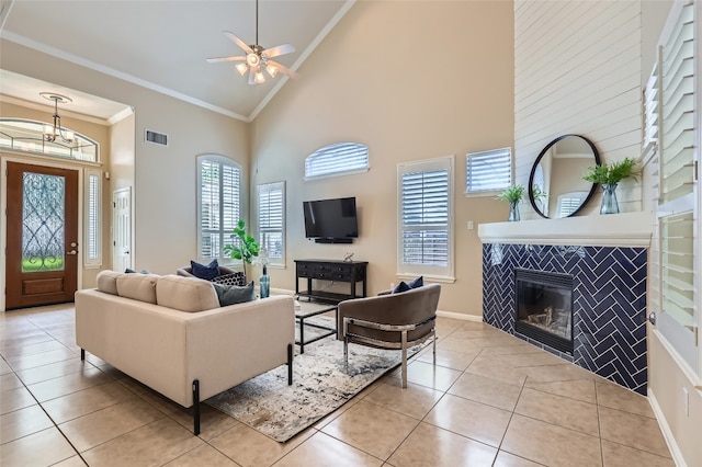2503 Kinclaven Ct, Cedar Park, TX 78613 - living room featuring high vaulted ceiling, crown molding, light tile patterned floors, a tiled fireplace, and a ceiling fan