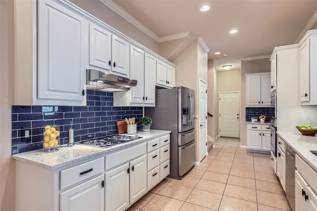 2503 Kinclaven Ct, Cedar Park, TX 78613 - kitchen featuring appliances with stainless steel finishes, under cabinet range hood, white cabinetry, light tile patterned floors, and tasteful backsplash