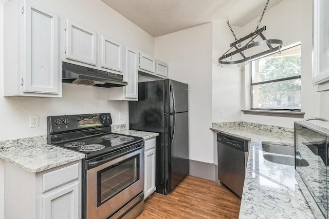 421 W San Antonio St Unit H1, San Marcos, TX 78666 - kitchen with appliances with stainless steel finishes, under cabinet range hood, light wood-style flooring, light stone counters, and a chandelier