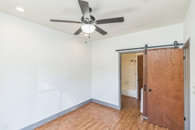 421 W San Antonio St Unit H1, San Marcos, TX 78666 - unfurnished room with ceiling fan, light wood-style flooring, baseboards, a barn door, and recessed lighting