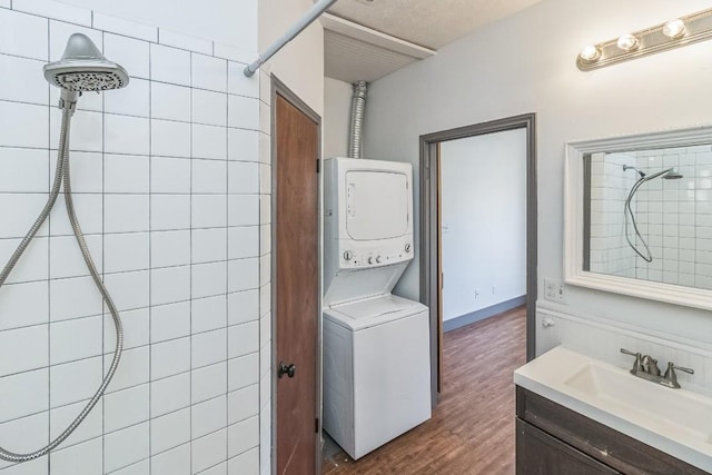 421 W San Antonio St Unit H1, San Marcos, TX 78666 - bathroom with stacked washing machine and dryer, vanity, a tile shower, and wood finished floors