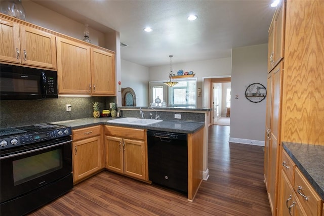 11525 Fm 86th Rd, Lockhart, TX 78644 - kitchen with black appliances, a peninsula, a sink, dark wood finished floors, and backsplash