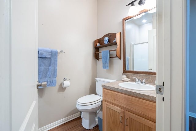 11525 Fm 86th Rd, Lockhart, TX 78644 - full bathroom with toilet, vanity, wood finished floors, a shower, and baseboards