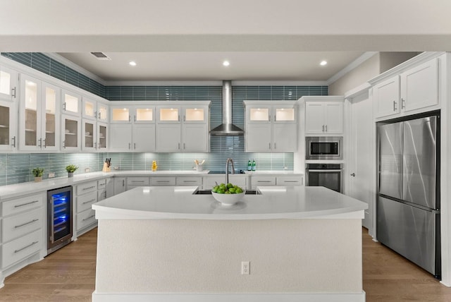 5502 Patagonia Pass, Austin, TX 78738 - kitchen with appliances with stainless steel finishes, beverage cooler, wall chimney exhaust hood, a sink, and light countertops