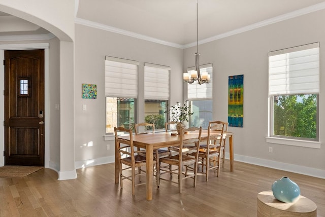 5502 Patagonia Pass, Austin, TX 78738 - dining area with arched walkways, wood finished floors, baseboards, ornamental molding, and a chandelier