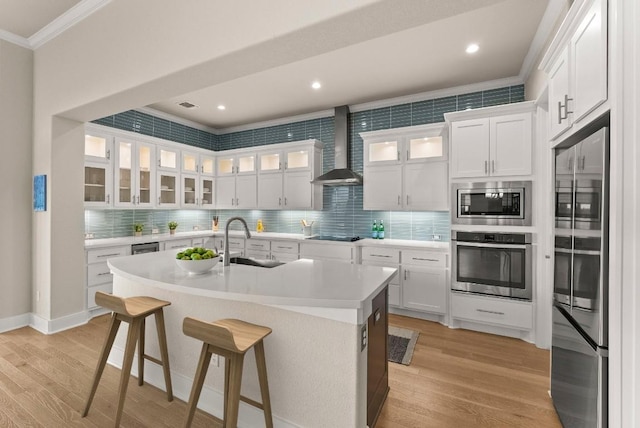5502 Patagonia Pass, Austin, TX 78738 - kitchen with appliances with stainless steel finishes, ornamental molding, wall chimney exhaust hood, light wood-style flooring, and light countertops