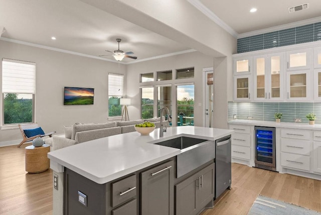5502 Patagonia Pass, Austin, TX 78738 - kitchen with wine cooler, a sink, crown molding, light countertops, and open floor plan