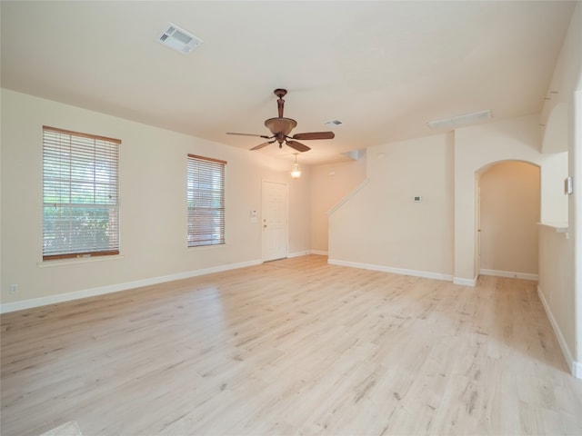 1010 Barclay Dr, Leander, TX 78641 - unfurnished living room featuring arched walkways, ceiling fan, light wood-style flooring, and baseboards