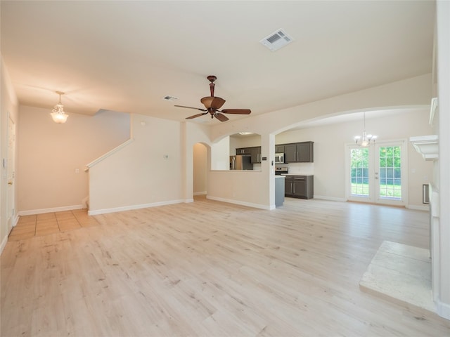 1010 Barclay Dr, Leander, TX 78641 - unfurnished living room with arched walkways, light wood-style floors, a chandelier, baseboards, and ceiling fan