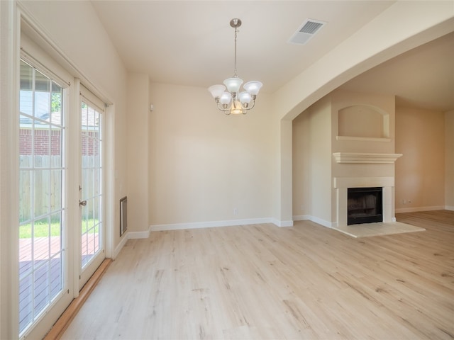 1010 Barclay Dr, Leander, TX 78641 - unfurnished living room with a chandelier, light wood-type flooring, arched walkways, and baseboards