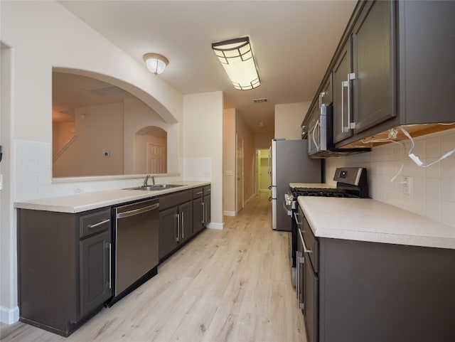 1010 Barclay Dr, Leander, TX 78641 - kitchen with stainless steel appliances, a sink, light wood finished floors, and tasteful backsplash