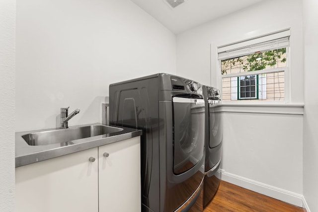 2004 Bremen St, Austin, TX 78703 - laundry room with washing machine and dryer, wood finished floors, cabinet space, and baseboards