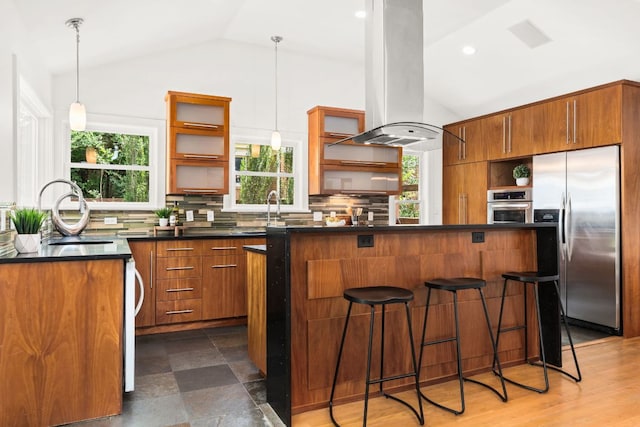 2004 Bremen St, Austin, TX 78703 - kitchen with stainless steel appliances, open shelves, island exhaust hood, vaulted ceiling, and brown cabinets