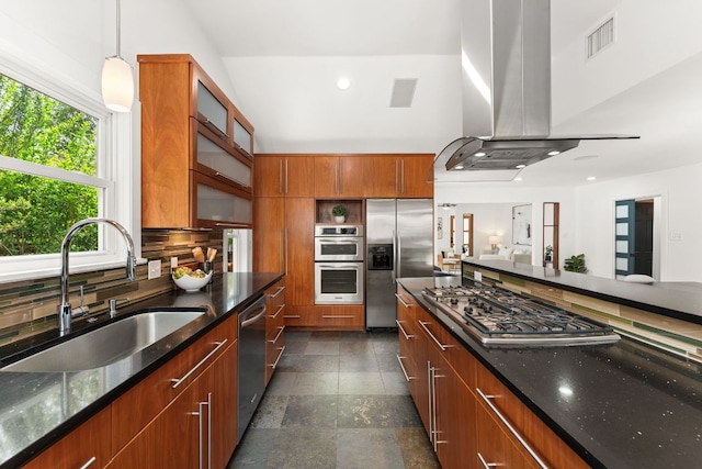 2004 Bremen St, Austin, TX 78703 - kitchen with appliances with stainless steel finishes, island exhaust hood, a sink, brown cabinetry, and decorative backsplash