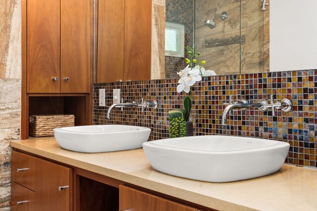 2004 Bremen St, Austin, TX 78703 - bathroom featuring tile walls, double vanity, a shower with shower door, and backsplash