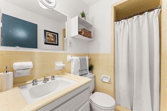 2004 Bremen St, Austin, TX 78703 - full bath featuring toilet, vanity, tile walls, a shower with shower curtain, and wainscoting