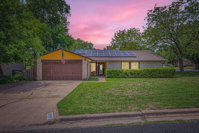 7900 Keneshaw Dr, Austin, TX 78745 - mid-century inspired home with a garage, a front yard, roof mounted solar panels, driveway, and brick siding