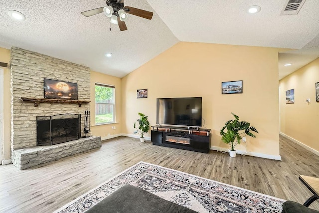 7900 Keneshaw Dr, Austin, TX 78745 - living room featuring wood finished floors, a fireplace, a ceiling fan, a textured ceiling, and baseboards