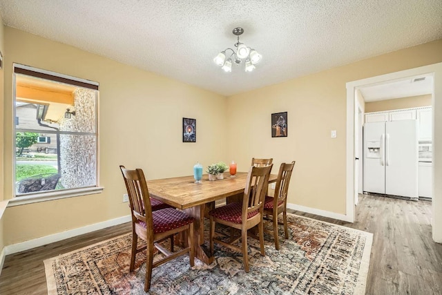 7900 Keneshaw Dr, Austin, TX 78745 - dining room with wood finished floors, a chandelier, baseboards, and a textured ceiling