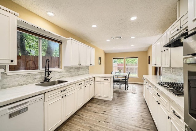 7900 Keneshaw Dr, Austin, TX 78745 - kitchen featuring white dishwasher, stainless steel gas cooktop, a sink, a textured ceiling, and light countertops