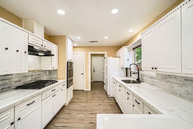 7900 Keneshaw Dr, Austin, TX 78745 - kitchen featuring stainless steel appliances, a sink, white cabinets, and recessed lighting