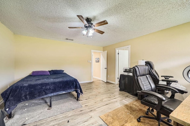 7900 Keneshaw Dr, Austin, TX 78745 - bedroom featuring light wood-type flooring, a textured ceiling, baseboards, an office area, and a ceiling fan