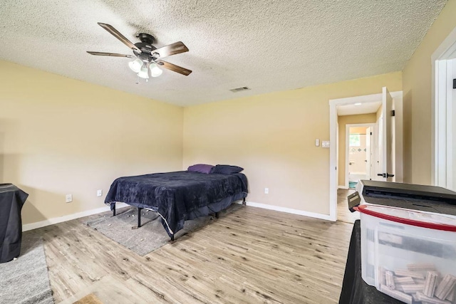 7900 Keneshaw Dr, Austin, TX 78745 - bedroom featuring light wood-style floors, a textured ceiling, ceiling fan, and baseboards