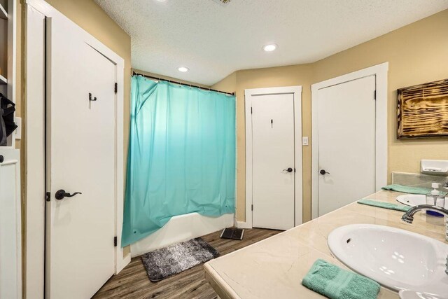 7900 Keneshaw Dr, Austin, TX 78745 - bathroom featuring wood finished floors, vanity, shower / bath combination with curtain, recessed lighting, and a textured ceiling