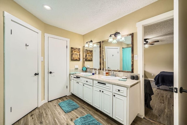 7900 Keneshaw Dr, Austin, TX 78745 - ensuite bathroom featuring double vanity, a textured ceiling, wood finished floors, ceiling fan, and recessed lighting