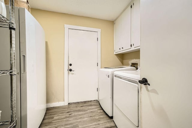 7900 Keneshaw Dr, Austin, TX 78745 - laundry area with cabinet space, washing machine and dryer, light wood-style flooring, and baseboards