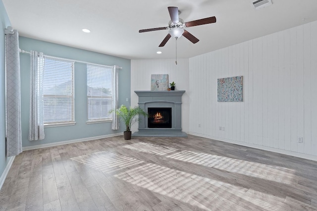2809 Coral Valley Dr, Leander, TX 78641 - unfurnished living room featuring ceiling fan, wood finished floors, a warm lit fireplace, and recessed lighting