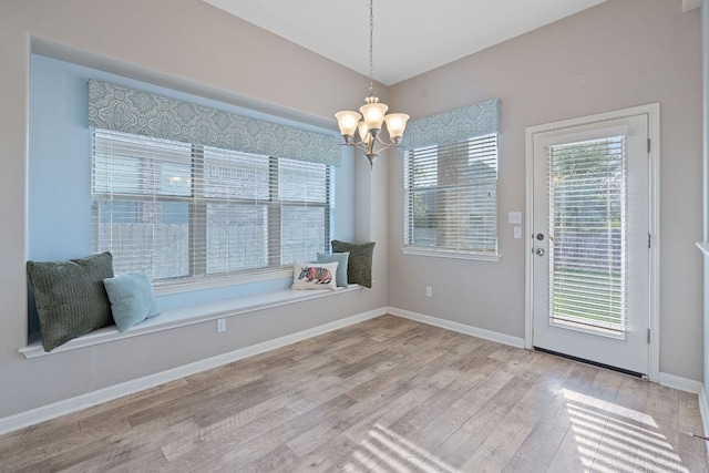 2809 Coral Valley Dr, Leander, TX 78641 - unfurnished dining area with wood finished floors, a chandelier, and baseboards