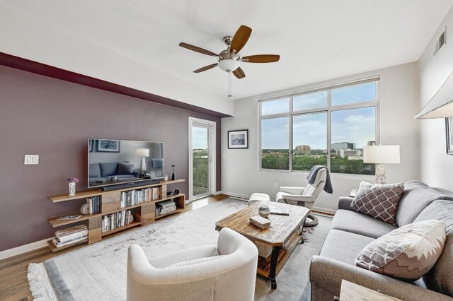 54 Rainey St Unit 814, Austin, TX 78701 - living room featuring wood finished floors, ceiling fan, and baseboards