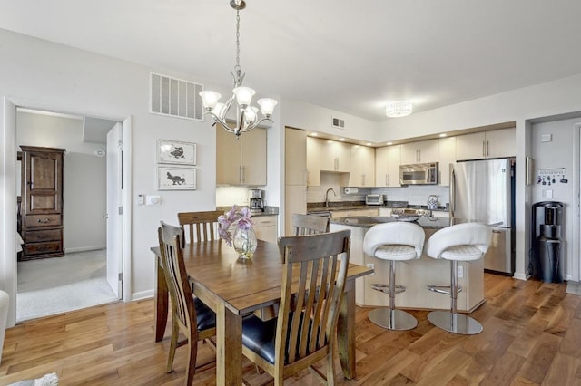 54 Rainey St Unit 814, Austin, TX 78701 - dining space featuring light wood-type flooring and a chandelier