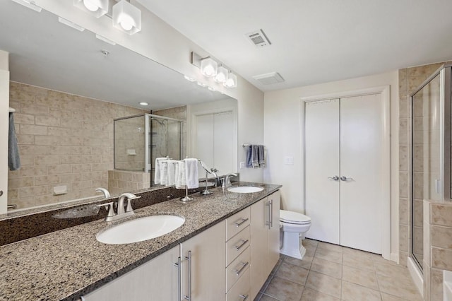54 Rainey St Unit 814, Austin, TX 78701 - bathroom featuring a stall shower, double vanity, tile patterned flooring, and toilet