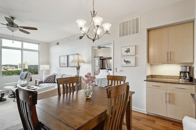 54 Rainey St Unit 814, Austin, TX 78701 - dining room featuring ceiling fan, light wood-style floors, a chandelier, and baseboards