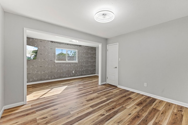 3312 Broken Spoke Trl, Georgetown, TX 78628 - unfurnished bedroom with wood finished floors, baseboards, and wallpapered walls