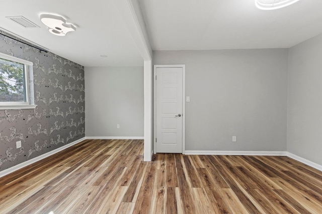 3312 Broken Spoke Trl, Georgetown, TX 78628 - spare room featuring wood finished floors, wallpapered walls, and baseboards