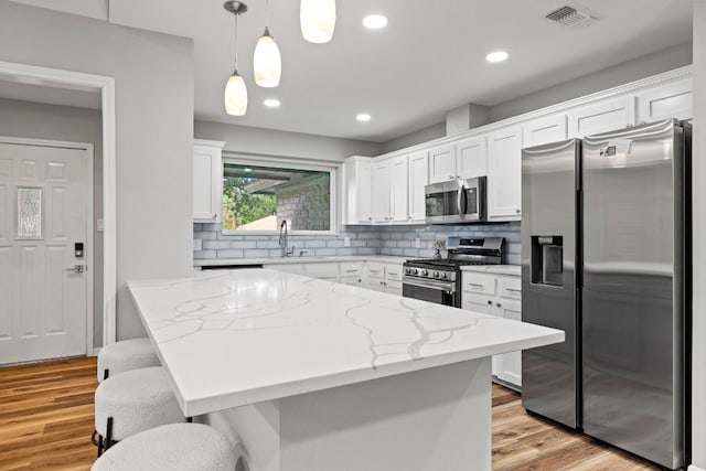 3312 Broken Spoke Trl, Georgetown, TX 78628 - kitchen featuring stainless steel appliances, white cabinets, a sink, tasteful backsplash, and light stone countertops