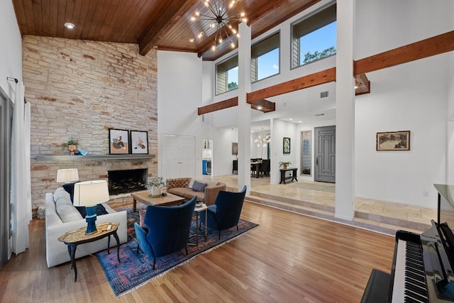 3101 Fleece Flower Cv, Austin, TX 78735 - living area with a stone fireplace, wood finished floors, a towering ceiling, a chandelier, and wood ceiling with exposed beams