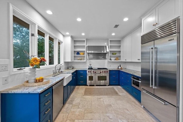3101 Fleece Flower Cv, Austin, TX 78735 - kitchen featuring premium appliances, blue cabinets, a sink, open shelves, and decorative backsplash
