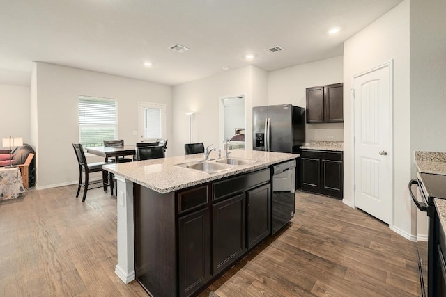 15000 Upland Willow Rd, Austin, TX 78724 - kitchen featuring stainless steel fridge with ice dispenser, dishwasher, an island with sink, wood finished floors, and a sink