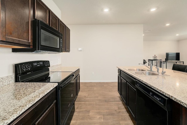 15000 Upland Willow Rd, Austin, TX 78724 - kitchen featuring black appliances, a sink, light wood-type flooring, recessed lighting, and baseboards