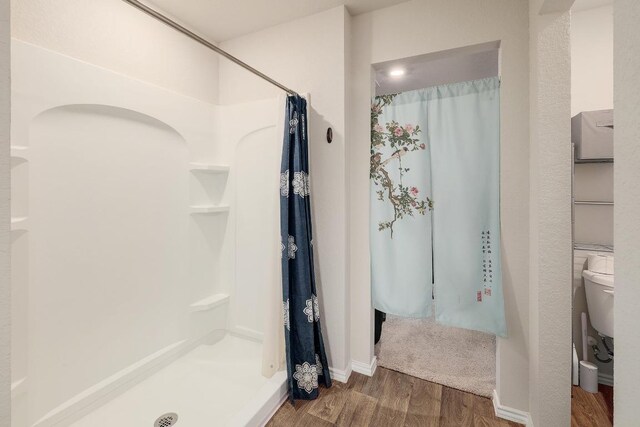 15000 Upland Willow Rd, Austin, TX 78724 - full bathroom featuring wood finished floors, a shower with curtain, toilet, and baseboards