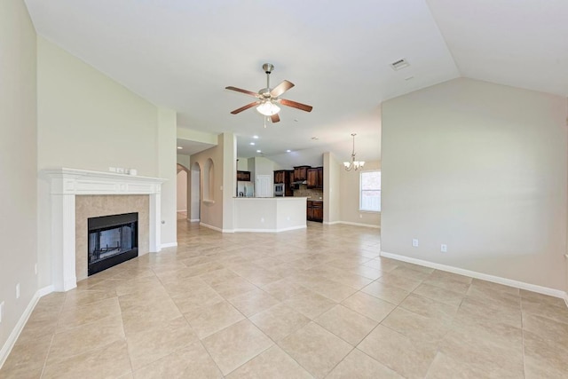 1803 Valle Verde Dr, Cedar Park, TX 78641 - unfurnished living room featuring vaulted ceiling, a ceiling fan, a tiled fireplace, light tile patterned flooring, and a chandelier