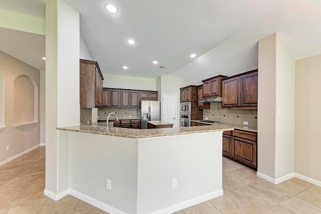 1803 Valle Verde Dr, Cedar Park, TX 78641 - kitchen featuring stainless steel appliances, vaulted ceiling, backsplash, light tile patterned floors, and under cabinet range hood