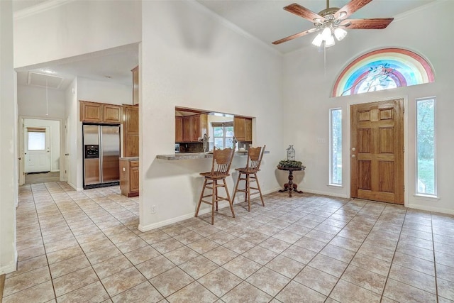 900 Cedar Park Dr, Cedar Park, TX 78613 - foyer featuring a towering ceiling, a ceiling fan, light tile patterned floors, crown molding, and baseboards
