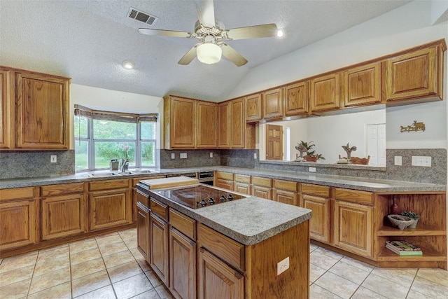 900 Cedar Park Dr, Cedar Park, TX 78613 - kitchen featuring black electric stovetop, a sink, brown cabinets, lofted ceiling, and a textured ceiling