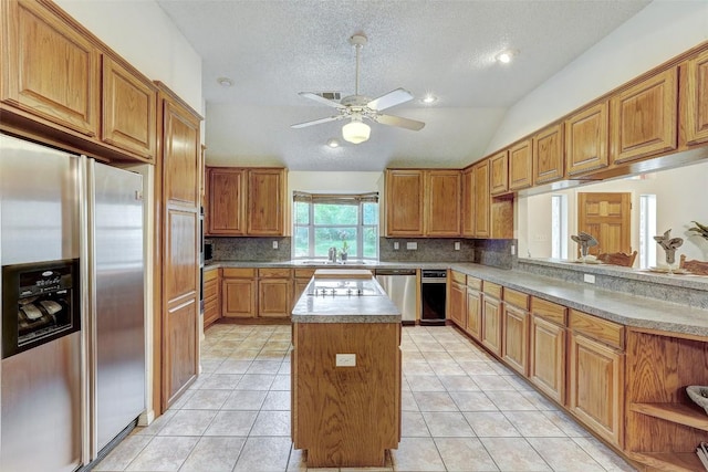 900 Cedar Park Dr, Cedar Park, TX 78613 - kitchen featuring appliances with stainless steel finishes, a center island, decorative backsplash, a ceiling fan, and a textured ceiling